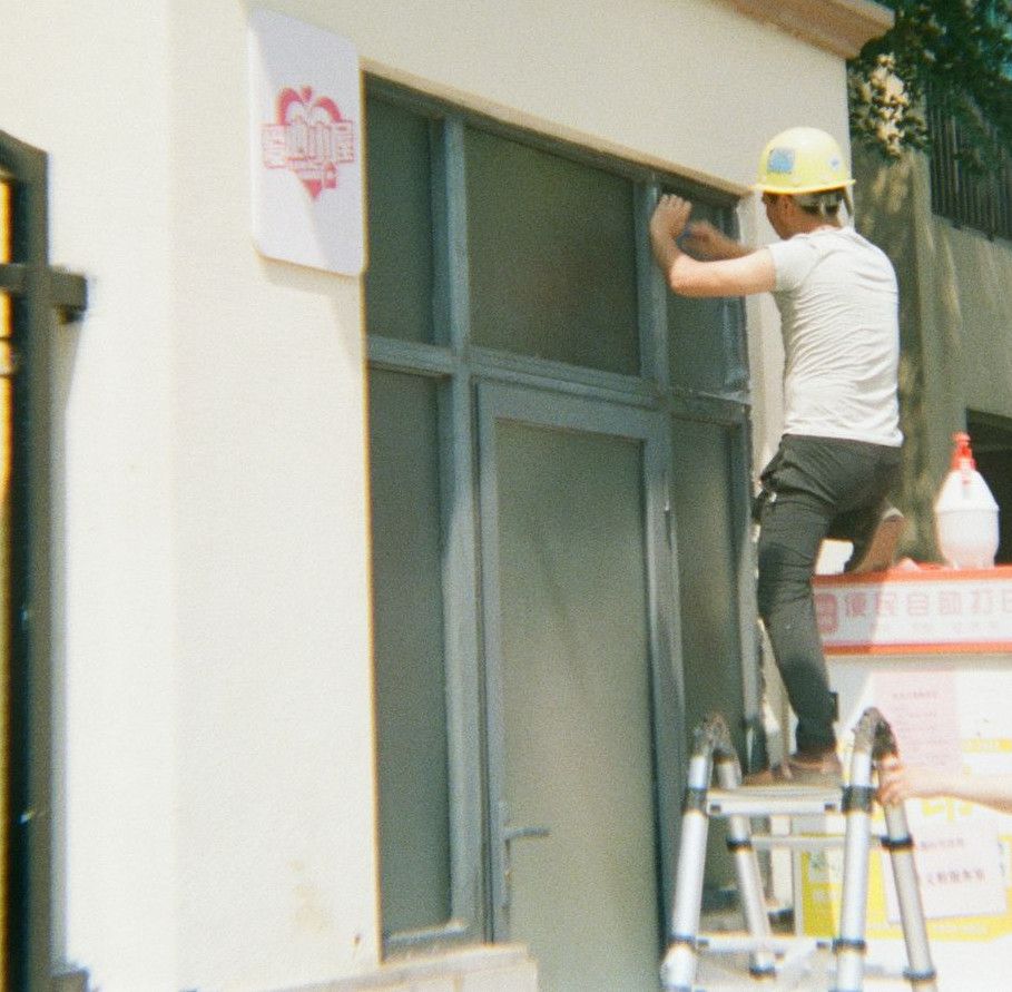 Two men working on a building exterior.